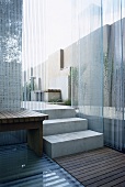 Modern, garden patio area, neutral stone walls, wooden table, decking, steps, glass walls,  gardens, minimalist, patios, bench seat, minimal