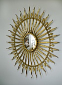 Spiegel mit goldenem Rahmen in Sonnenform