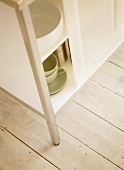 Crockery in white storage cabinet with sliding doors.