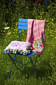 A cushion on a blue metal garden chair