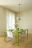 Grüner Esstisch mit Stühlen und Hängelampe im Designerstil
