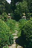 A wild garden with a stone pillar either side of the path