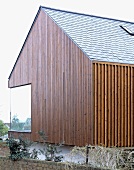 Vertical wood panelling on a newly built house with a corner window
