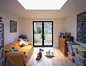 A sofa with a yellow cover in a child's room with a terrace door