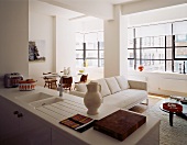 A kitchen counter in an open-plan living-room-cum-dining-room with a window bank