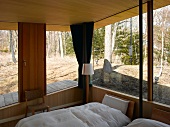 A corner of a bedroom in a newly built house with beds by a corner window