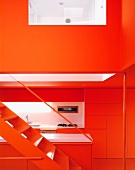 N open stairway with a view of a modern, red kitchen