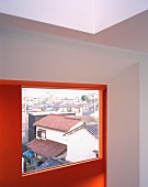 A room with a red wall and a window