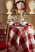 Herbstlich gedeckter Tisch mit karierter Tischdecke, Granatapfel und Windlicht