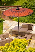 Wicker furniture on a terrace under a red sunshade