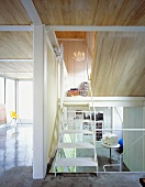 An open modern stairway with a view of a study and an anteroom