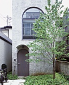 Baum und Eingangsbereich vor turmartigen Neubauhaus, The Tower House, Tokio, Japan