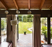 A living room with an open terrace door and a view into a garden