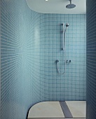 A shower cubicle with a curved wall and turquoise mosaic tiles