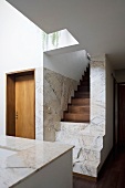 A modern, newly built house with a flight of marble and wood stairs