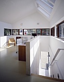 A modern attic room with a window bank and a white flight of stairs