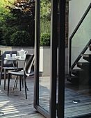Blick durch offene Terrassentür auf Tisch mit Kaffeekanne und Tassen