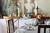 A table laid with roses, candles and green glasses