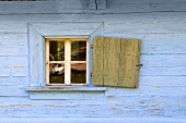 Blaue Holzhütte mit geöffnetem Fensterladen