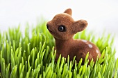 A fawn toy in dewy grass