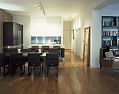 Table with upholstered chairs in an open plan kitchen-dining room with wood flooring