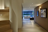 Modern foyer with walls in shades of brown and a view of a sofa in front of a bank of windows