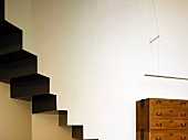 Rustikale Holzkommode an Wand neben Treppe in zeitgenössischer Architektur