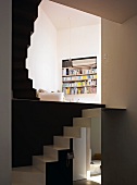 Living area with open, multi-level staircase and view of bookshelves