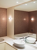 Rosafabenes modernes Bad mit weisser Waschschüssel vor grossem Wandspiegel