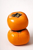 Two persimmons, stacked
