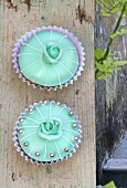 Two turquoise cupcakes with roses and silver dragees