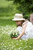 A little girl with daisies in a flowering medow