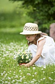 Kleines Mädchen mit Margeriten auf Blumenwiese