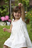 A little girl holding up a cherry