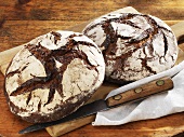 Two rustic country loaves on a chopping board