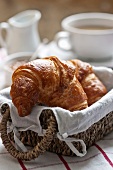 Croissants in a bread basket with coffee