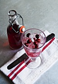 Cranberry juice and a glass of cranberries and ice cubes