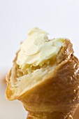 A croissant with butter (close-up)