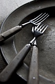 Three old forks on an old plate