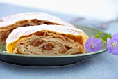 Two pieces of apple strudel with raisins and hazel nuts