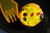 A fruit muffin and fork (seen from above)