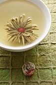 A bowl of jasmine tea with a tea rose