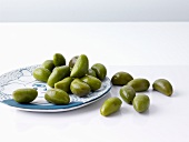 Grüne Oliven auf Teller und daneben