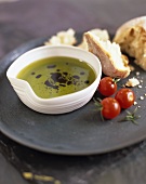 A dish of olive oil, cherry tomatoes and ciabatta