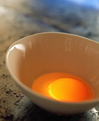 Egg yolk in a small white bowl