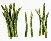 Several spears of green asparagus on white background