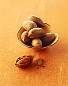 Several pecan nuts in a wooden bowl