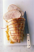 Roast turkey, slices carved, on a board with knife
