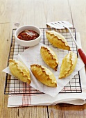 Several meat pasties with tomato relish