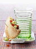 Pita bread filled with vegetables leaning against a glass